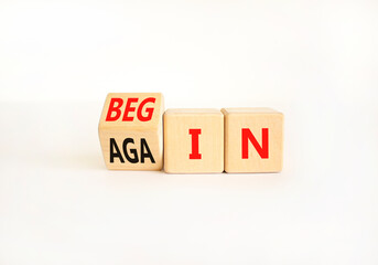 Wall Mural - Begin again symbol. Businessman turns wooden cubes and changes the word begin to again. Beautiful white table white background. Business and begin again concept. Copy space.