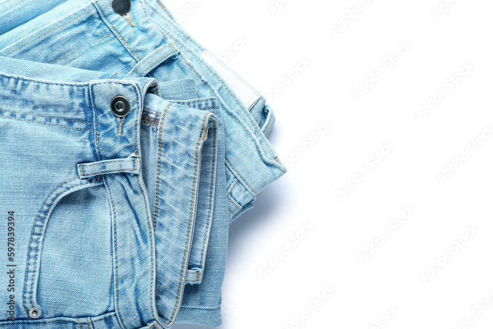 Folded jeans on white background, closeup