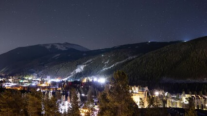 Wall Mural - Time lapse of a mountain and night sky in Colorado. Snow grooming equpment can be see moving on a nearby ski resort.