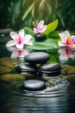 Fototapeta Desenie - Pyramids of balanced zen pebble meditation stones with green leaves and flowers in water on tropical forest background. Concept of harmony, balance and meditation, spa, massage, relax and yoga.