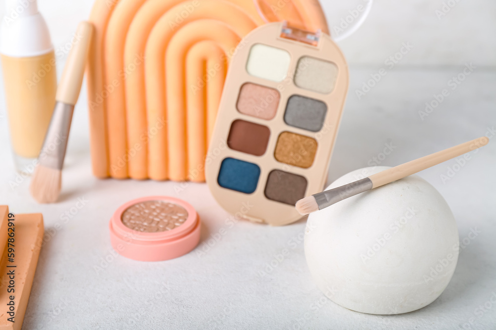 Decorative plaster podiums and cosmetics on light background