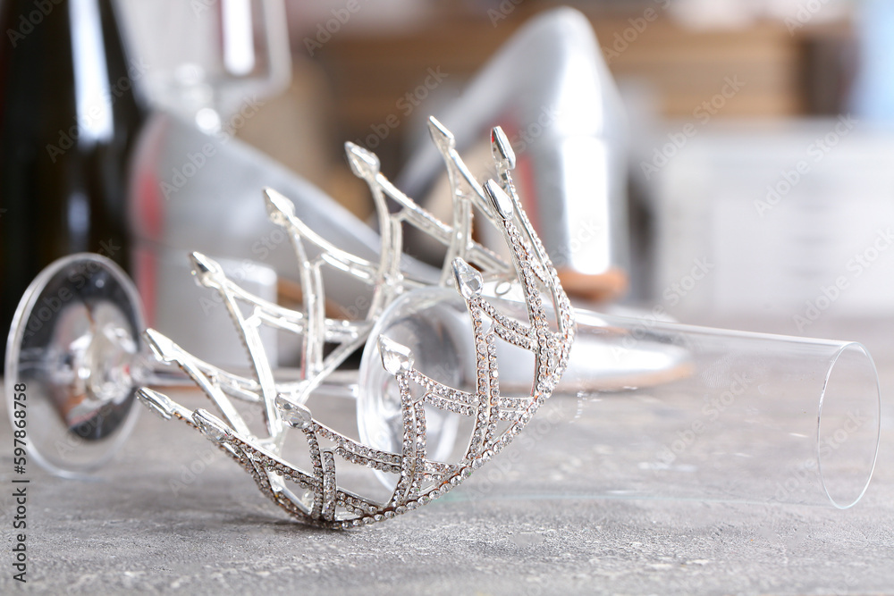 Beautiful crown with glass on grey table, closeup. Prom concept