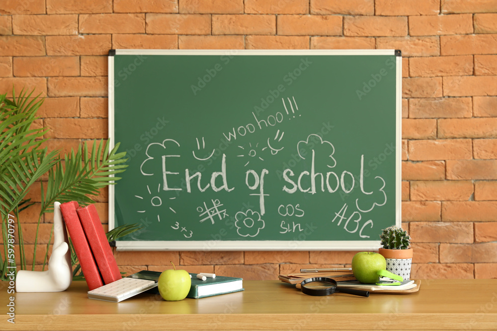 Blackboard with text END OF SCHOOL and drawings in classroom