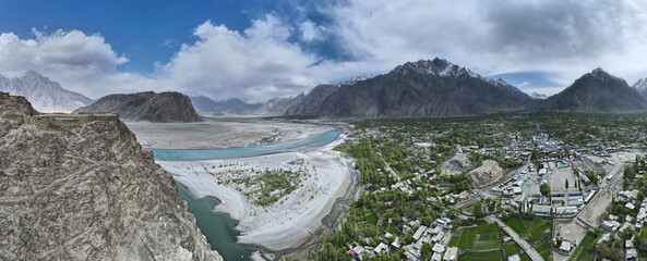 A 180-degree aerial panorama of Skardu Valley, Indus River delta, and Kharpocho Fort located on a mountain overlooking the entire valley in Skardu, Pakistan