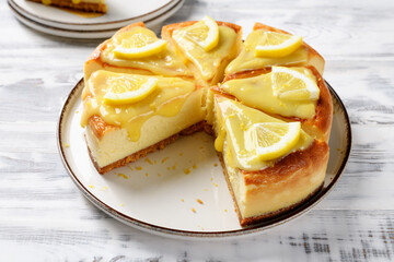 Wall Mural - Sliced Fresh baked homemade lemon cheesecake with lemon curd and lemon slices.