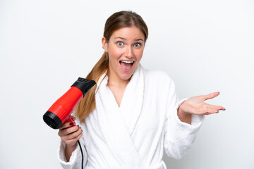 Wall Mural - Young caucasian woman holding hairdryer isolated on white background with shocked facial expression