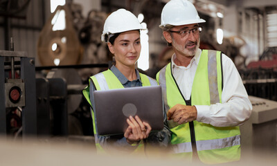 Wall Mural - Senior manager train female technician to work in metalwork production factory. Industrial engineer man and woman standing in manufacturing facility talking machinery technology in heavy industry.