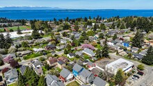 Aerial View Of A Suburban Seattle City On A Sunny Fall Day With A View Of Puget Sound In The Distance