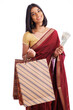 Cheerful South Indian woman in traditional saree and holding shopping bags with Indian currency isolated on white.