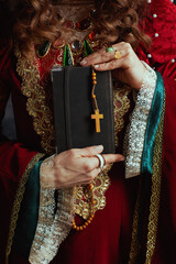 Wall Mural - Closeup on medieval queen in red dress with book and rosary