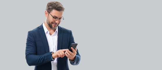 Man in suit using smart phone. Portrait attractive cheerful guy using phone, calling on mobile phone. Handsome man with smart phoneon studio isolated background. Banner, copy space.