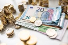 Euro Banknotes And Coins Togetger On White Table - Close-up