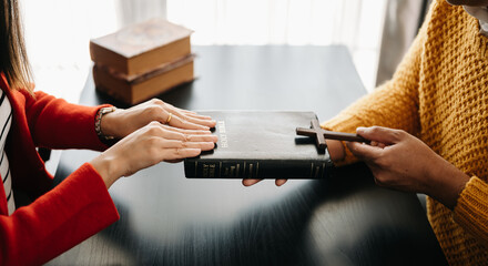 Woman's hand with cross .Concept of hope, faith, christianity, religion, church and pray to God. on the black table..