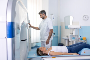 Wall Mural - Professional Doctor Radiologist In Medical Laboratory Controls magnetic resonance imaging or computed tomography or PET Scan with Female Patient Undergoing Procedure.