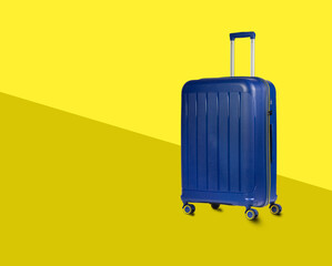 Wall Mural - Blue Plastic Trolley  Travel Case with Metal Handle over yellow stylish background