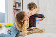 © Sandra - Two kids preschooler and toddler arguing about tablet toy, toddler girl is sad and crying, brother and sister playing and learning concept, negative emotions...