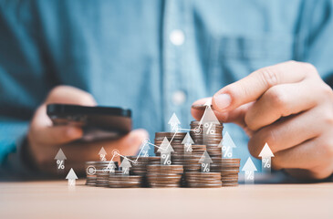 Wall Mural - Businessman holding coins stacking with up arrow for financial banking interest rate from money saving and business investment growth from dividend concept.