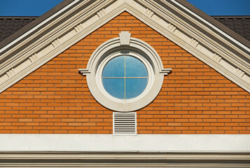 Wall Mural - Round window in a red brick wall on facade of a modern house. Architecture details of a modern building