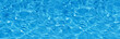 Transparent blue colored clear water surface texture with splashes.  Water background, ripple and flow with waves. Blue water shinning. Sea, ocean surface. Overhead top view. Flat lay design.