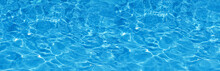 Transparent Blue Colored Clear Water Surface Texture With Splashes.  Water Background, Ripple And Flow With Waves. Blue Water Shinning. Sea, Ocean Surface. Overhead Top View. Flat Lay Design.