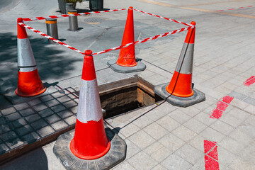 Street sinkhole repair . Red repair cones fencing the street 