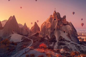 Wall Mural - Old ancient home cave in big stone, hot air balloons fly over deep canyons, valleys Cappadocia Goreme National Park, Turkey Travel tourist concept