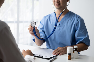 Wall Mural - Close up view of male pediatrician hold stethoscope while examing his patient.