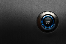 Engine start button with blue glowing ring on a modern car