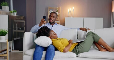Poster - Young Couple Using Laptop And Phone On Couch