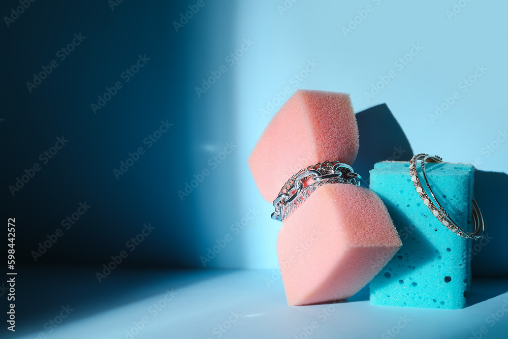 Sponges with jewelry on blue background