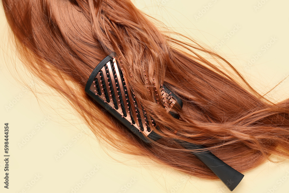 Ginger hair with brush on yellow background