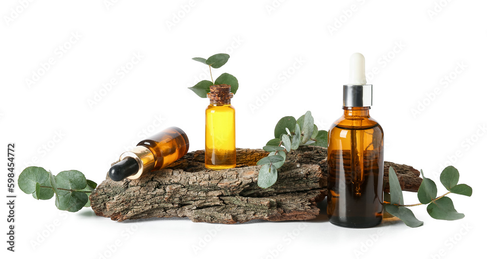Bottles with cosmetic oil, eucalyptus branch and tree bark on white background