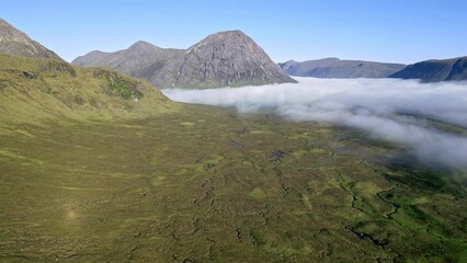 Wall Mural - Aerial view of remains of low banks of fog with mountain peaks at dawn (Glencoe, Scotland)