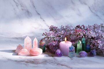 Wall Mural - Gemstones set, candle, lilac flowers on marble background. gemstones for Healing Crystal Ritual, esoteric spiritual practice, aura cleansing, relax. reiki therapy. Fluorite, amethyst, rose quartz