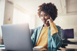 © Flamingo Images - Smiling young businesswoman on a laptop video call in an office