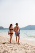 © Westend61 - Couple walking on sand at beach