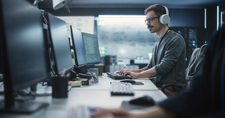 Aufkleber - System Administrator Working in a Research E-Business Facility on a Desktop Computer. Focused Software Developer in Casual Clothes Wearing Headphones and Updating Server System Database