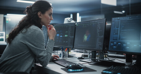 Fototapete - Portrait of a Thoughtful Young Engineer Working on Computer in a Technological Office Environment. Beautiful Multiethnic Woman Writing Software Code for a Blockchain Project