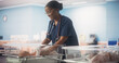 © Gorodenkoff - Cute Emotional Newborn Little Infant Lying in Hospital Cot. Young Black Pediatrician Taking Care of the Baby and Fixing the Blanket. Healthcare, Pregnancy and Motherhood Concept