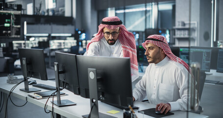 Poster - Young Team of Arab Specialists Working on Computers and Having a Conversation at a Workplace. Two Male Software Developers Discussing a Solution for Their Generative Artificial Intelligence Project