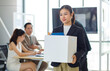 © Bangkok Click Studio - Asian professional successful new recruitment female employee businesswoman in formal business suit smiling standing moving in holding cardboard box containing paperwork document folder into office