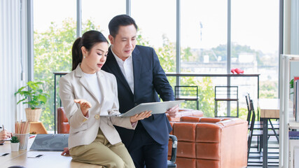 Asian professional successful female businesswoman secretary employee showing information strategy data via laptop notebook computer to male businessman manager in formal business suit in living room