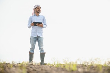 Young indian farmer at agriculture field.