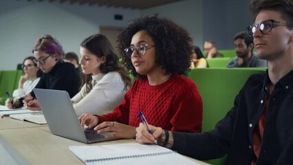 Fototapete - Beautiful Multiethnic African Female Student Studying in University with Diverse Classmates. Young Black Woman Using a Laptop Computer to Summarize the Lecture, Study at Home and Prepare for Exams