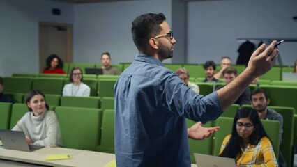 Poster - Male Teacher Giving a Lecture to a Diverse Multiethnic Group of Female and Male Students in Modern College Room. Curious and Thoughtful Scholars Studying and Listening to Lecturer. Camera Facing Class