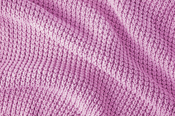 Pink knitted clothes in coarse knit with pleats and shadows as a background for the design