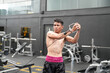 © FotoArtist - Young active athlete exercising on cross training equipment in fitness center or gym