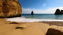 View of idyllic nature landscape with rocky cliff shore and waves crashing on. Camillo beach in Lagos. West Atlantic coast of Algarve region, south of Portugal.