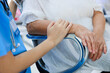 Close up hand holding together. Young asian doctor in blue uniform and senior woman holding hands together. Positive Asian woman caregiver helping patient.