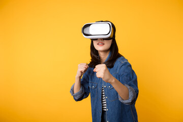 Poster - Young asian woman get experienced wearing virtual reality headset game entertainment isolated on yellow background. Winner of cyber future video game concept.